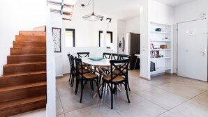 A modern kitchen with a central island, white cabinetry, and a built-in oven.