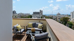 A rooftop terrace with outdoor furniture, a view of the cityscape, and a clear sky. - Penthouse with Terrace & Panoramic View by FeelHome (Tel Aviv - Jaffa)