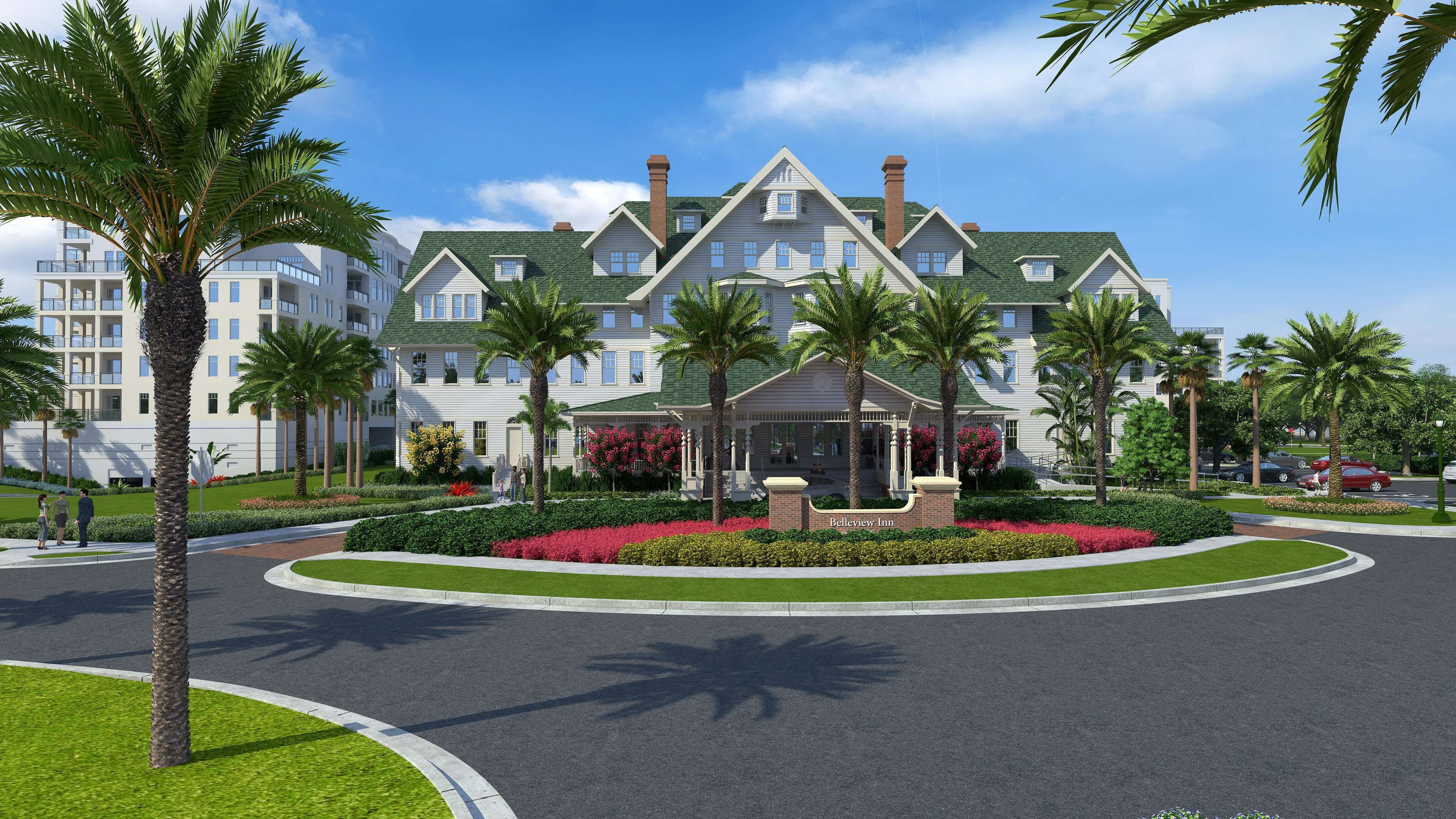 A large, multi-story hotel with a central courtyard, palm trees, and a well-maintained garden.