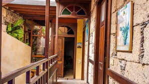 A narrow hallway with wooden railings and a stone wall. - Casa Luna (Agaete)