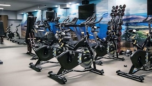 Un gimnasio con bicicletas estáticas, cintas de correr y máquinas de pesas.