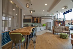 Eine moderne Küche mit Barbereich, Holzbarhocker und einem großen grünen Apfel als Mittelpunkt.