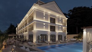 Un immeuble à plusieurs étages doté d’une piscine, d’un espace extérieur aménagé et d’un patio couvert.