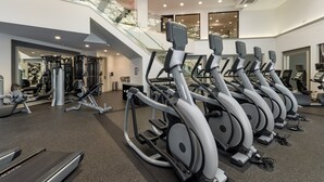 A gym with multiple treadmills, weight machines, and a staircase leading to an upper level. - Bluebird Suites in Silicon Valley (San Jose)