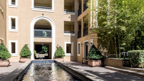 A multi-story building with a central courtyard, balconies, and potted plants. - Bluebird Suites in North San Jose (San Jose)