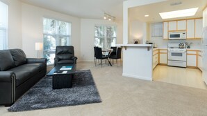 A modern apartment with a living room, dining area, and kitchen. - Bluebird Suites in North San Jose (San Jose)