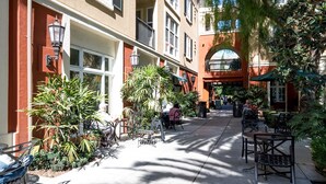 A courtyard with outdoor seating, surrounded by buildings with balconies and large windows. - Bluebird Suites in North San Jose (San Jose)