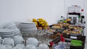 Een buffetopstelling met diverse gerechten, borden en bestek.