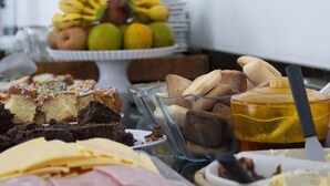 Een buffet met diverse desserts, fruit en een honinglepel.