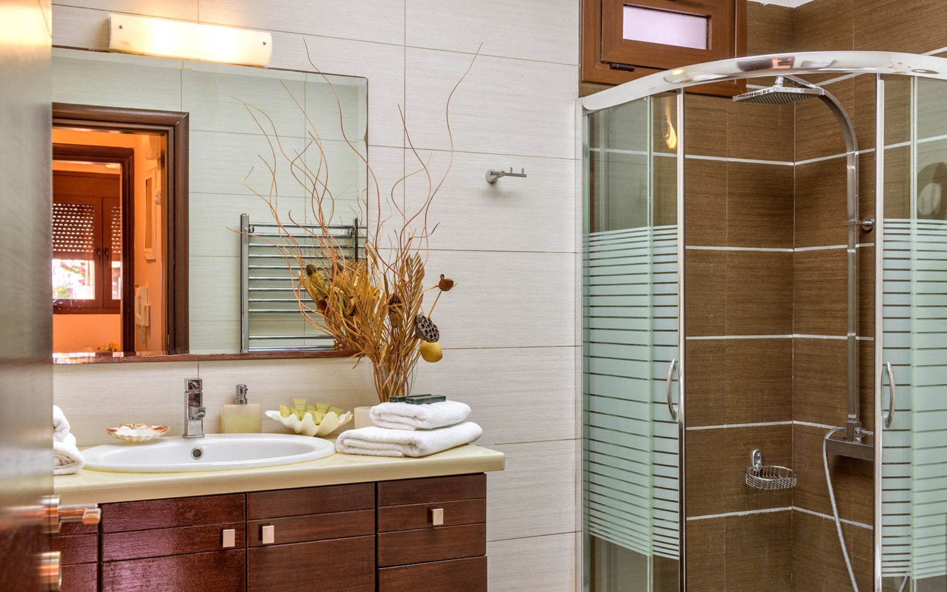 A bathroom with a sink, mirror, and shower.