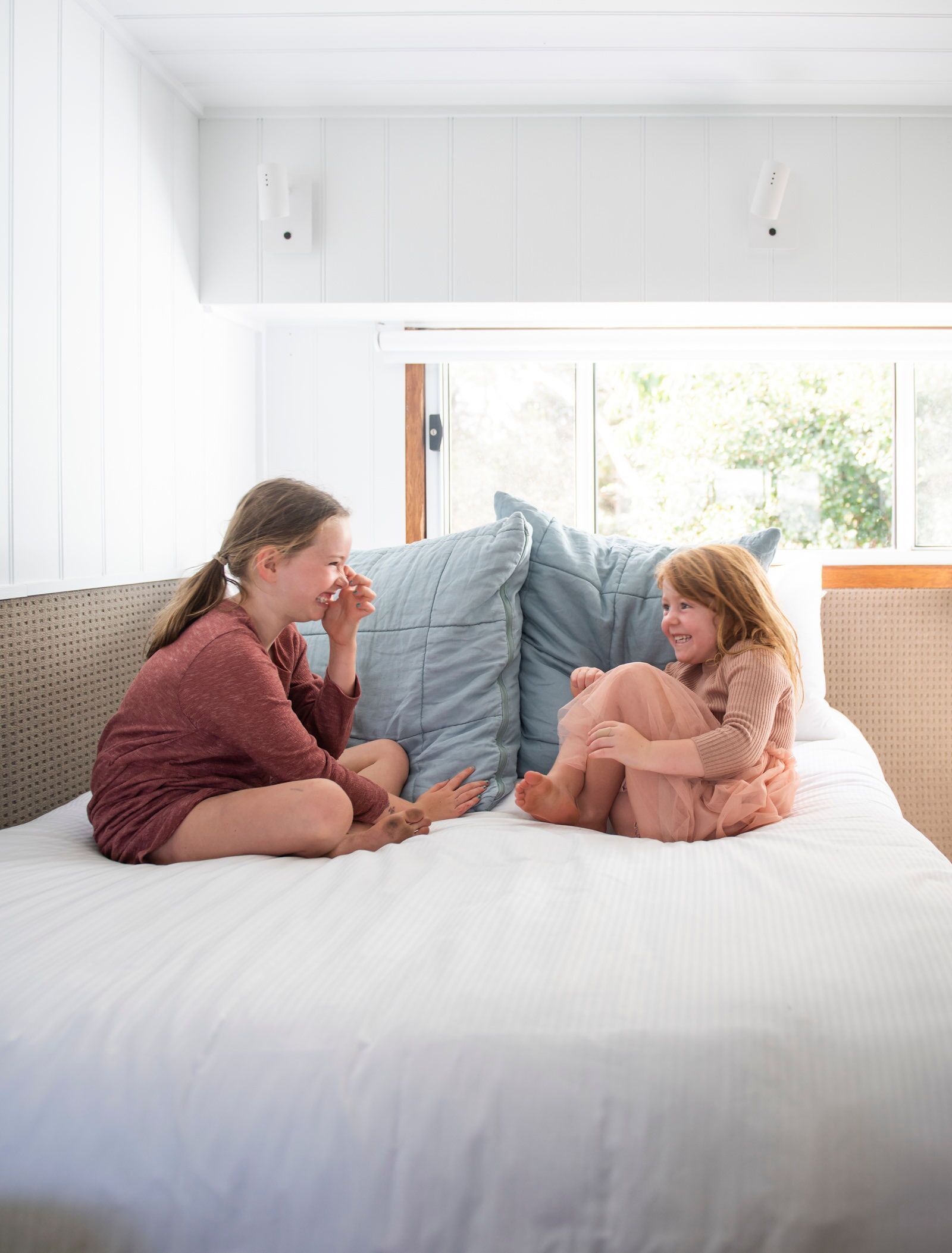 Ein Zimmer mit Bett, weißen Wänden und einem Fenster.