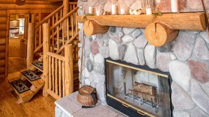 A log cabin interior with a stone fireplace, wooden shelves, and a mounted deer head. - Dancing Bear Lodge--Log Cabin Getaway (Fort Calhoun)
