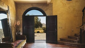 Una puerta abierta que da a un espacio exterior con vistas a un paisaje y montañas.