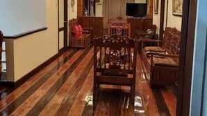 A hallway with wooden flooring, a chandelier, and a ceiling fan. - Tops Lodging House (San Juan)