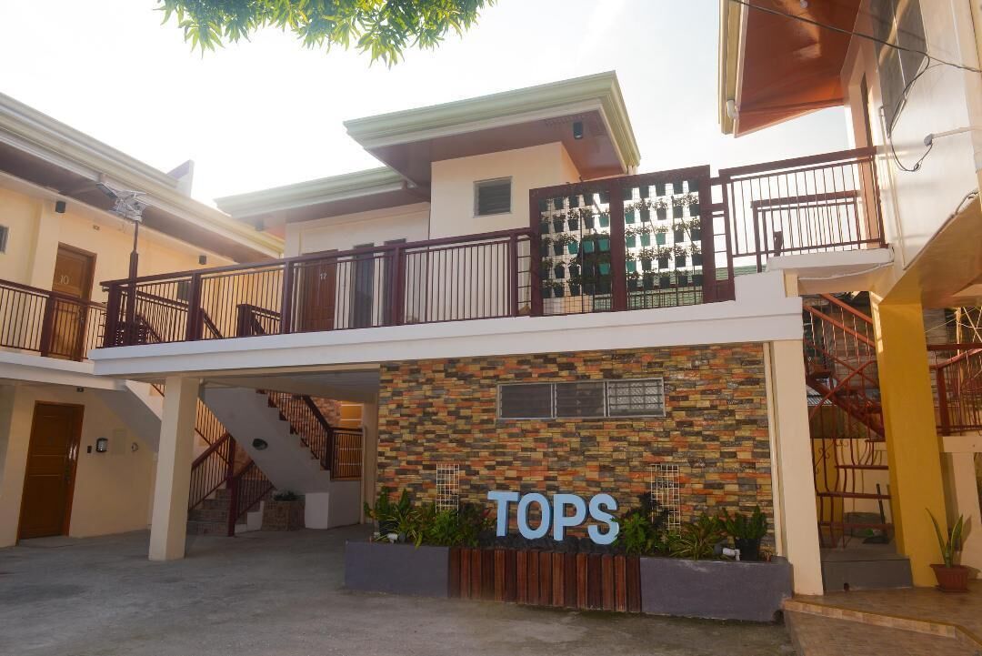 A multi-story building with a prominent 'TOPS' sign, a covered outdoor area, and a staircase leading to an upper level.