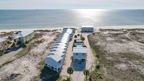 An aerial view of a coastal hotel with multiple buildings, a swimming pool, and a beach.