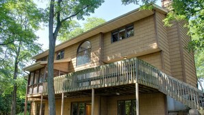 A two-story house with a wooden exterior, large windows, and a covered balcony. - Arbor Dell 1 Block from Lake Delton (Wisconsin Dells)