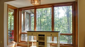 A room with a large window, a wooden cabinet, and a chair. - Arbor Dell 1 Block from Lake Delton (Wisconsin Dells)