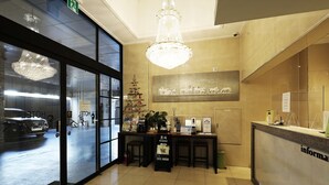 A hotel lobby with a reception desk, a Christmas tree, and a chandelier. - Russo Hotel (Gangneung)