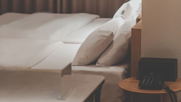 Ein Hotelzimmer mit Bett, Nachttisch und Telefon.