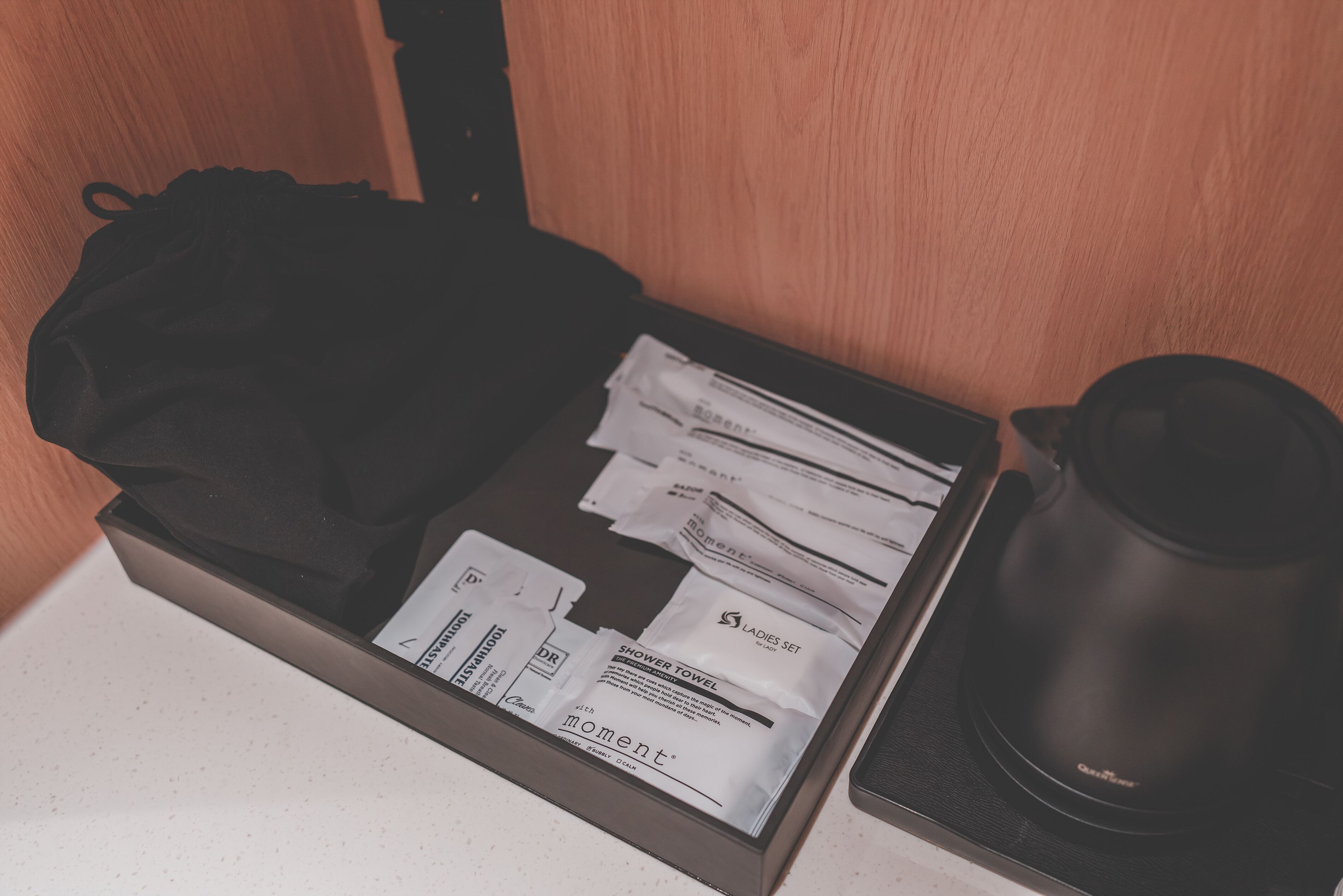 Un cajón con una bolsa negra, varios sobres blancos y un objeto negro.