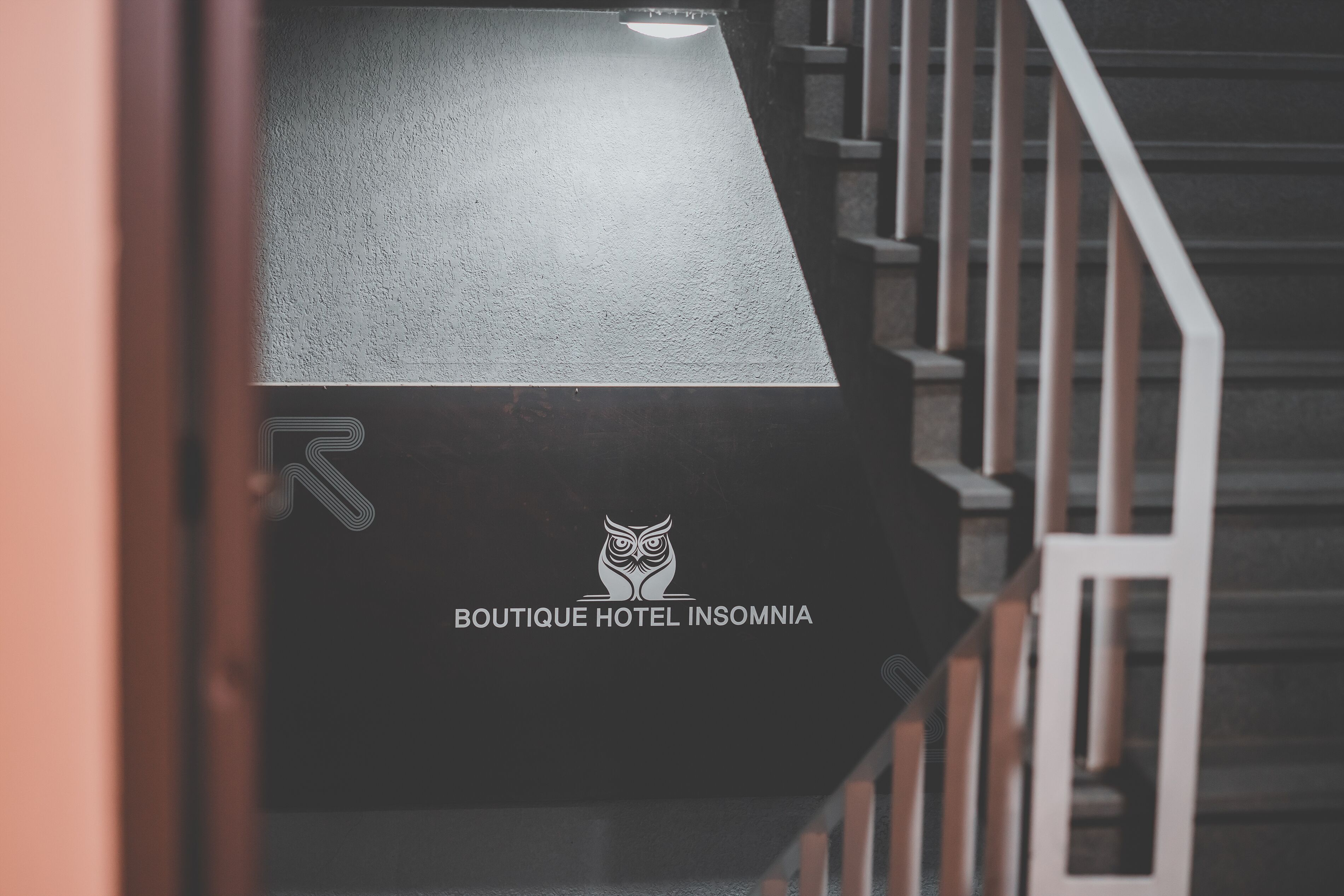 Una escalera con un cartel para el Boutique Hotel Insomnia.