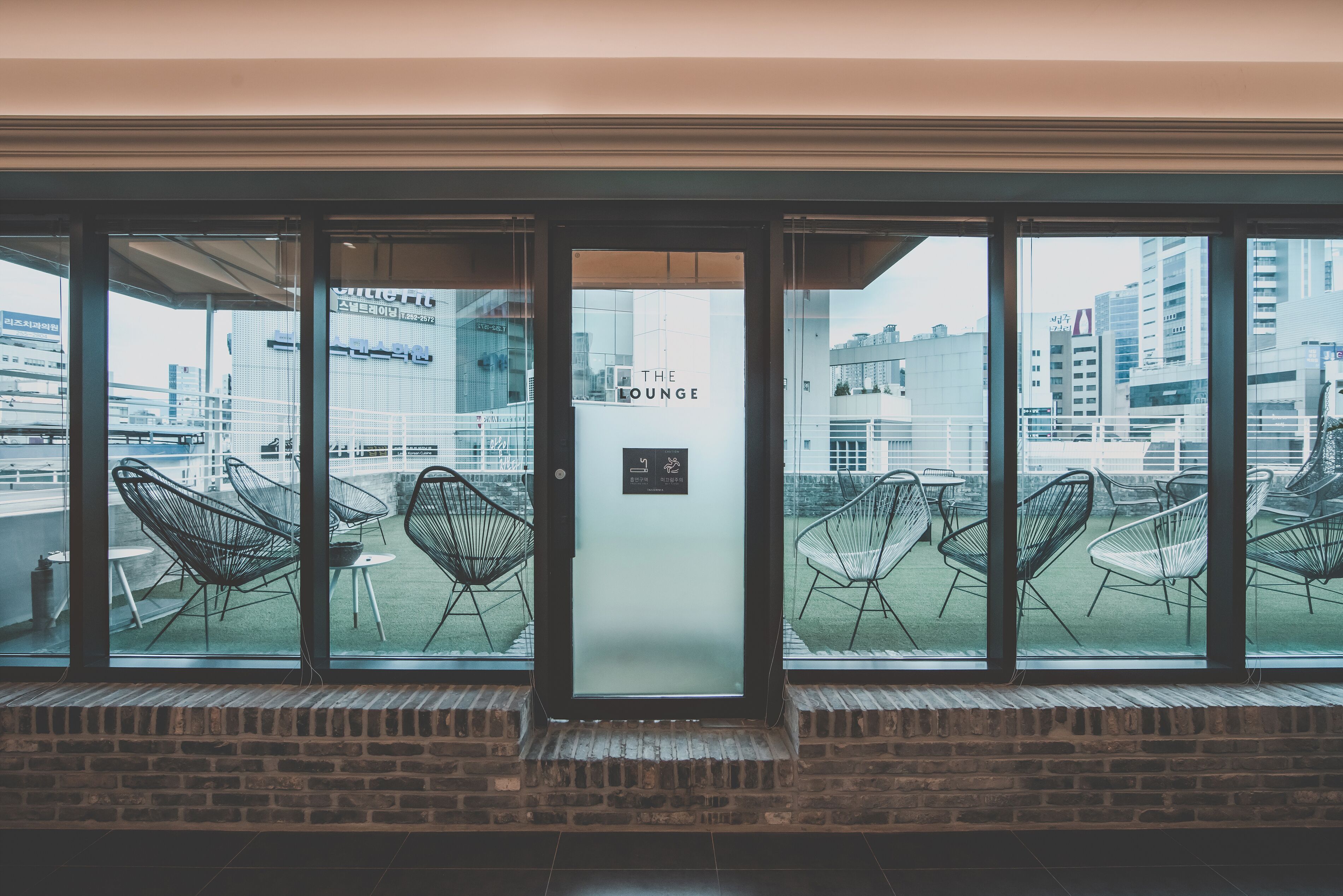 A hotel entrance with a view of the cityscape through large windows.