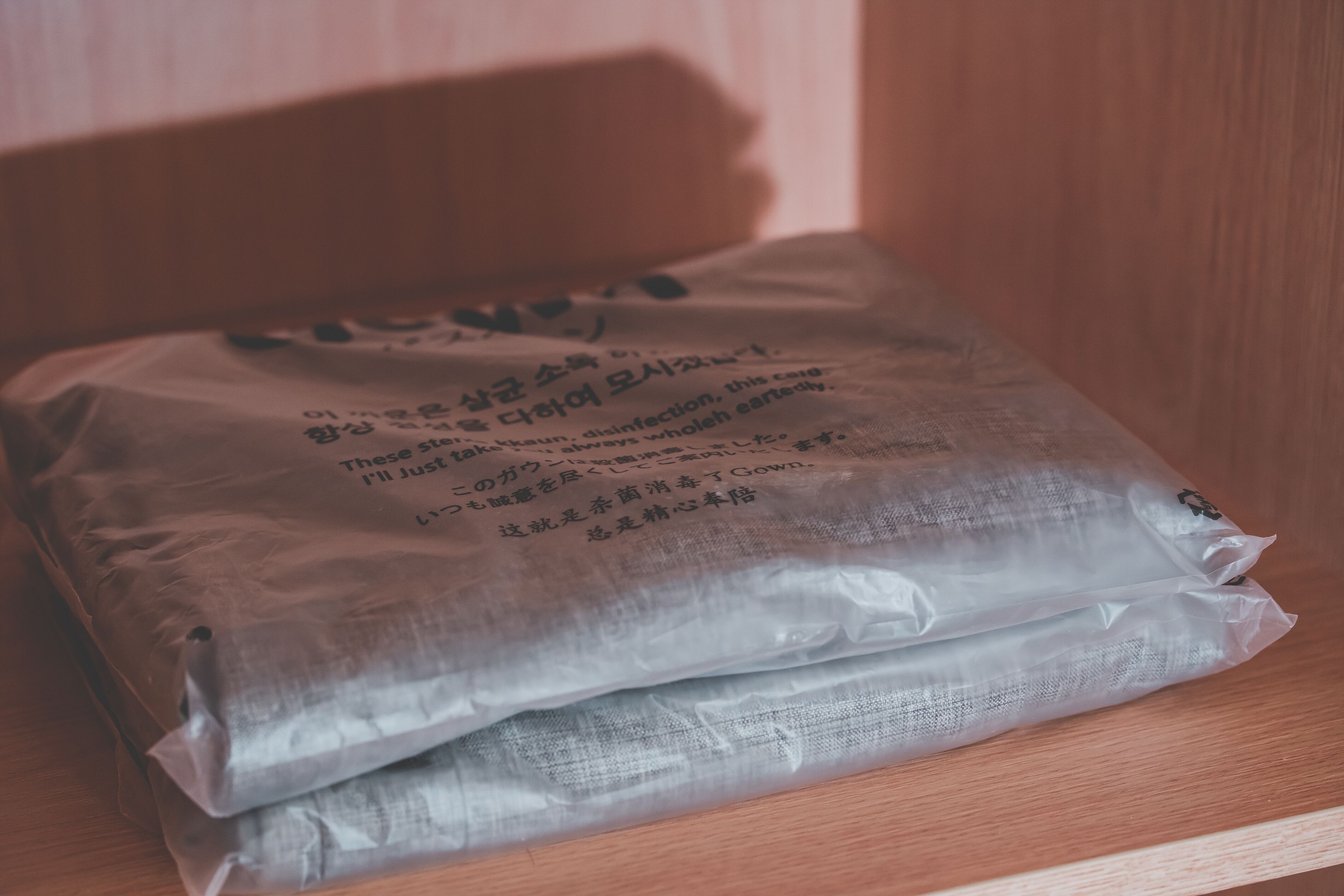 A plastic bag with text on it, placed on a wooden surface.