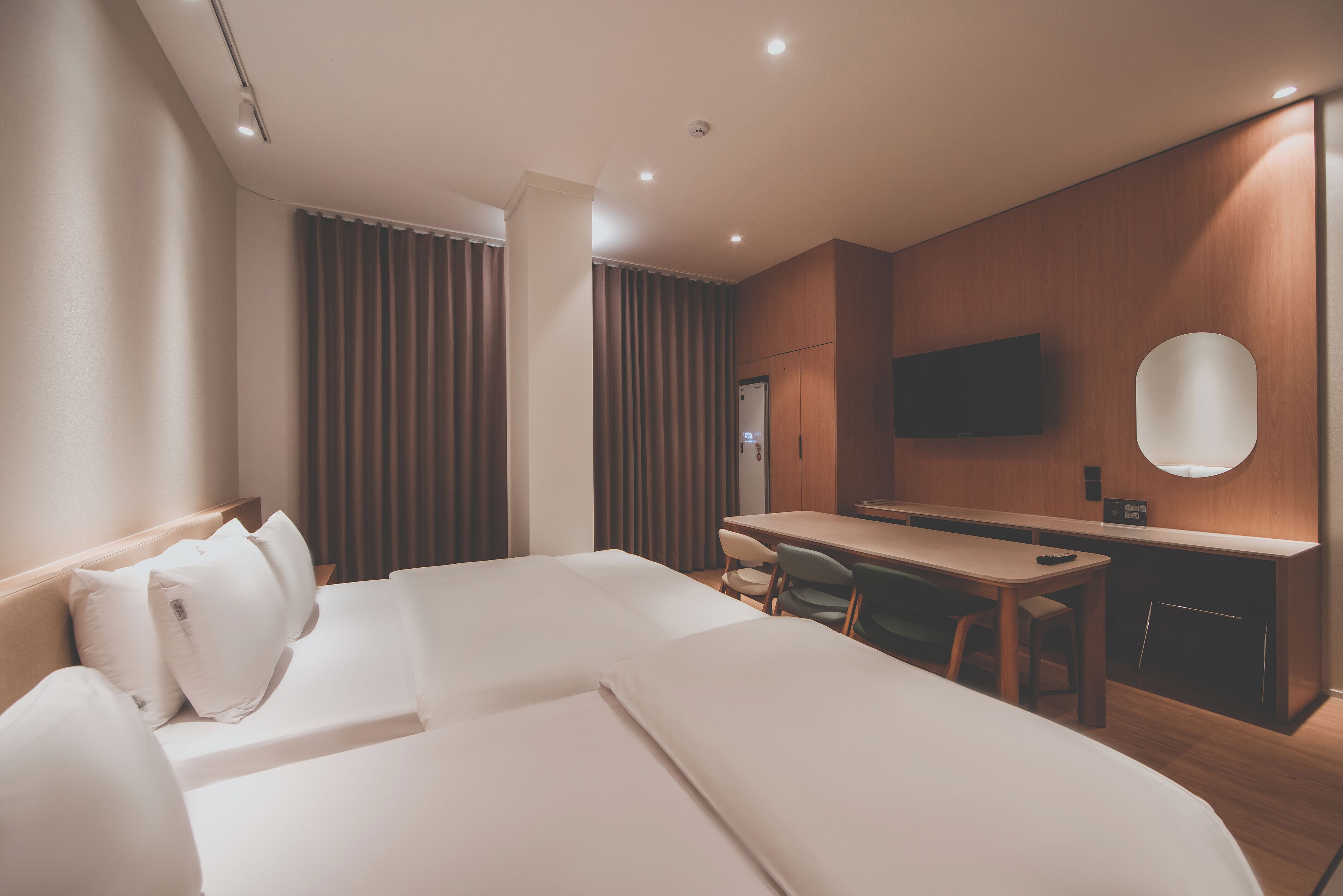 A hotel room with a bed, a desk, and a television.