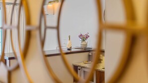 A kitchen with a countertop, a vase with flowers, and a bottle.