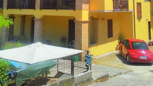 A two-story yellow building with a red car parked in front. - holiday home IL GIRASOLE (Castel Ritaldi)