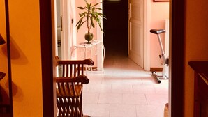 A hallway with a wooden bench, a potted plant, and a bicycle. - holiday home IL GIRASOLE (Castel Ritaldi)