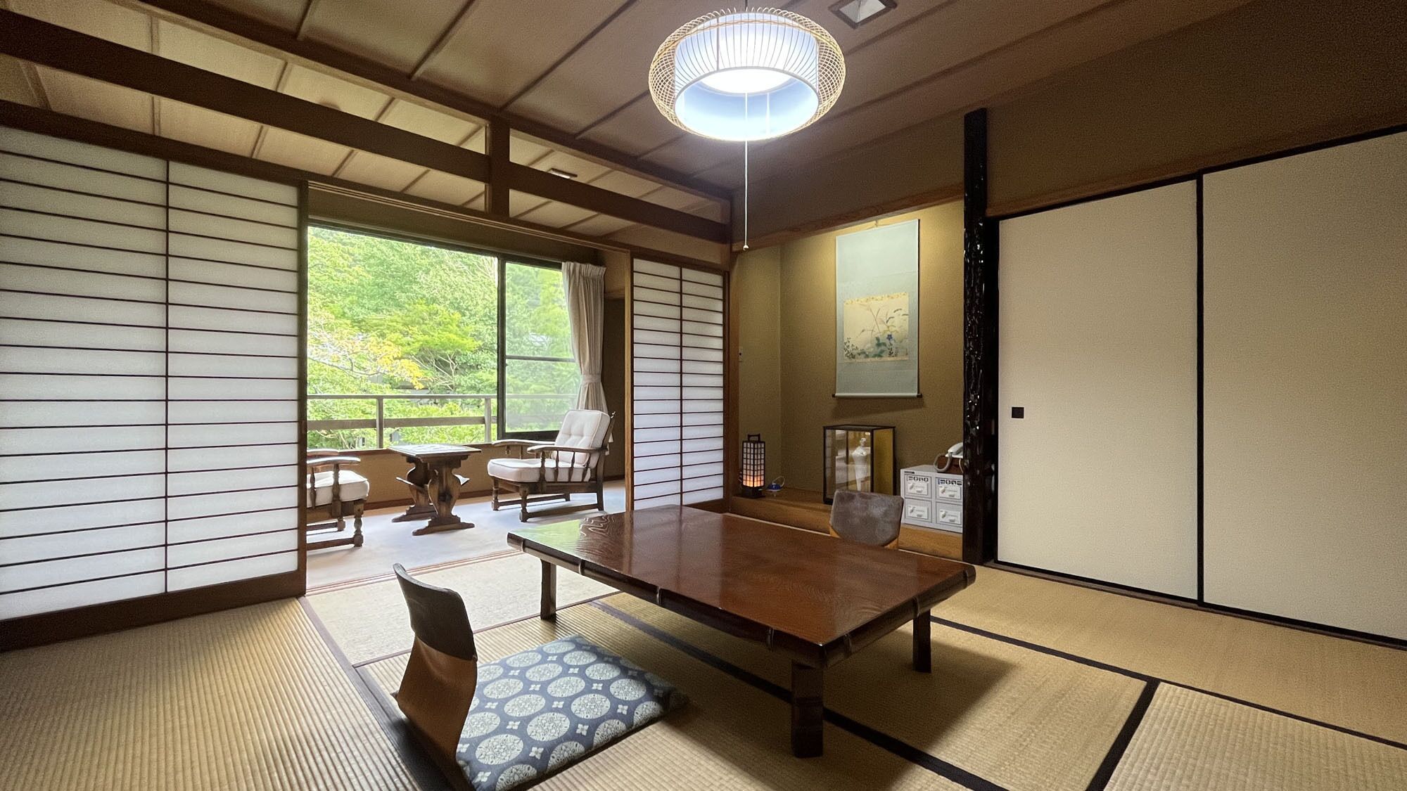 A traditional Japanese room with tatami flooring, a low table, and sliding doors.