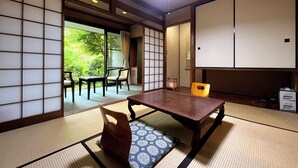 A traditional Japanese room with tatami flooring, a low table, and sliding doors.