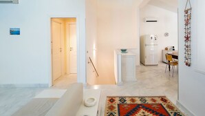Una cocina moderna con un refrigerador blanco, una mesa de comedor con sillas y un adorno en la pared.