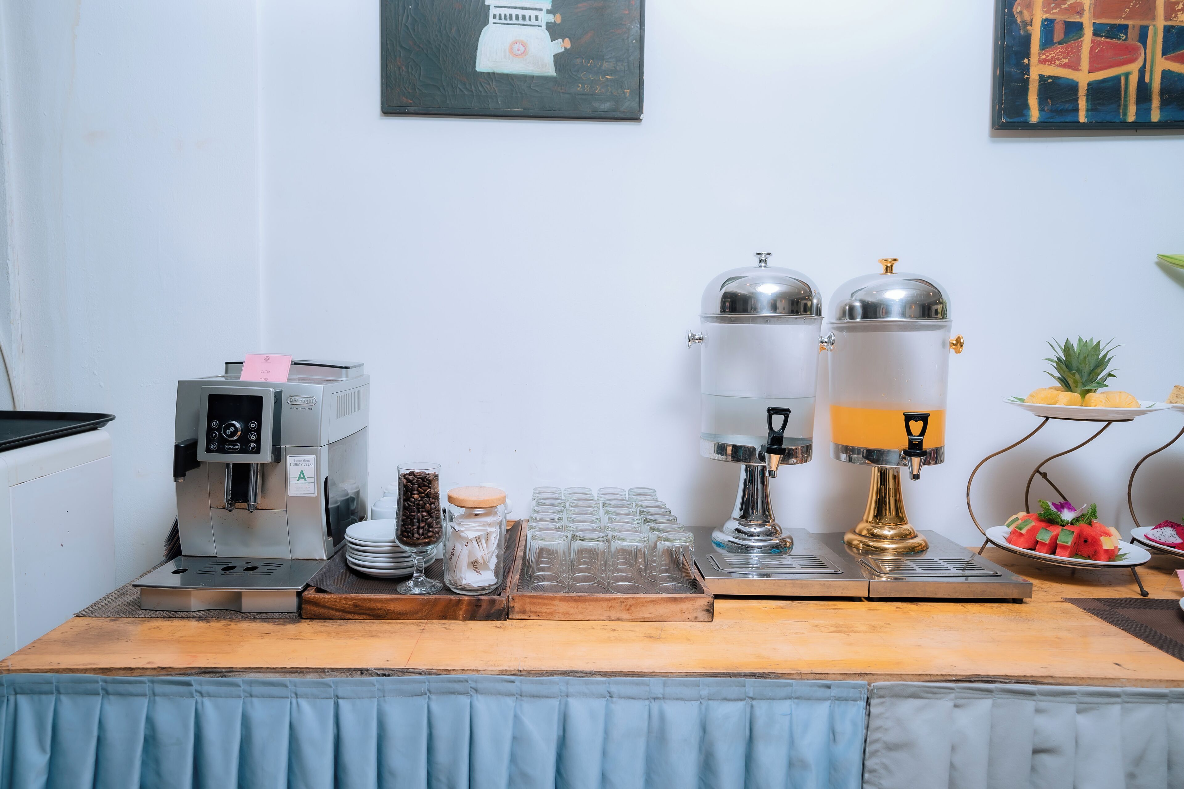 A coffee station with a coffee machine, two dispensers, and a tray of coffee cups.