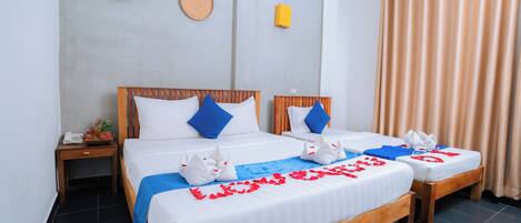 A hotel room with two beds, a bedside table with a phone, and a wall-mounted artwork.