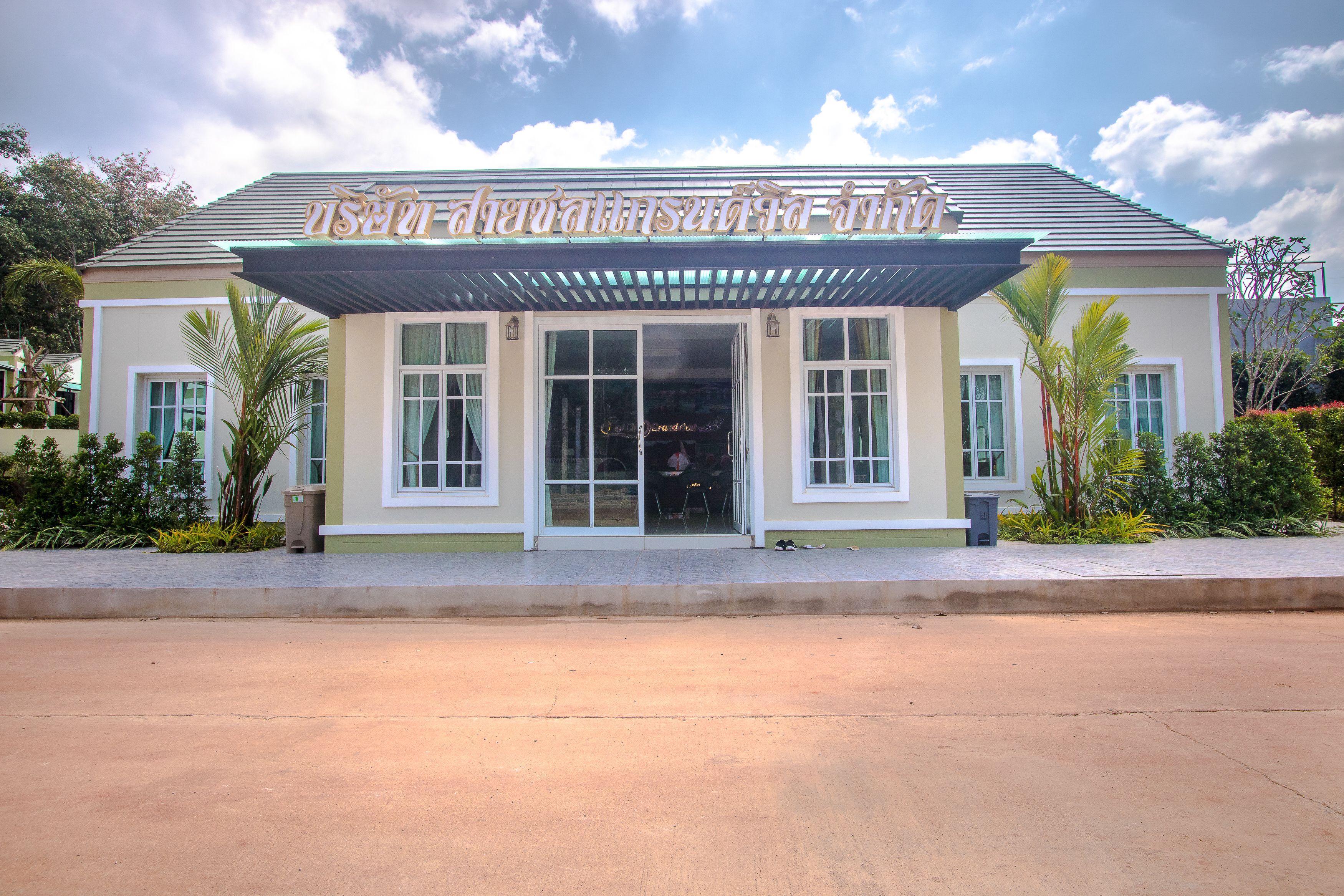 Un hôtel doté d’une entrée abritée, de grandes fenêtres et d’une enseigne dans une langue étrangère.