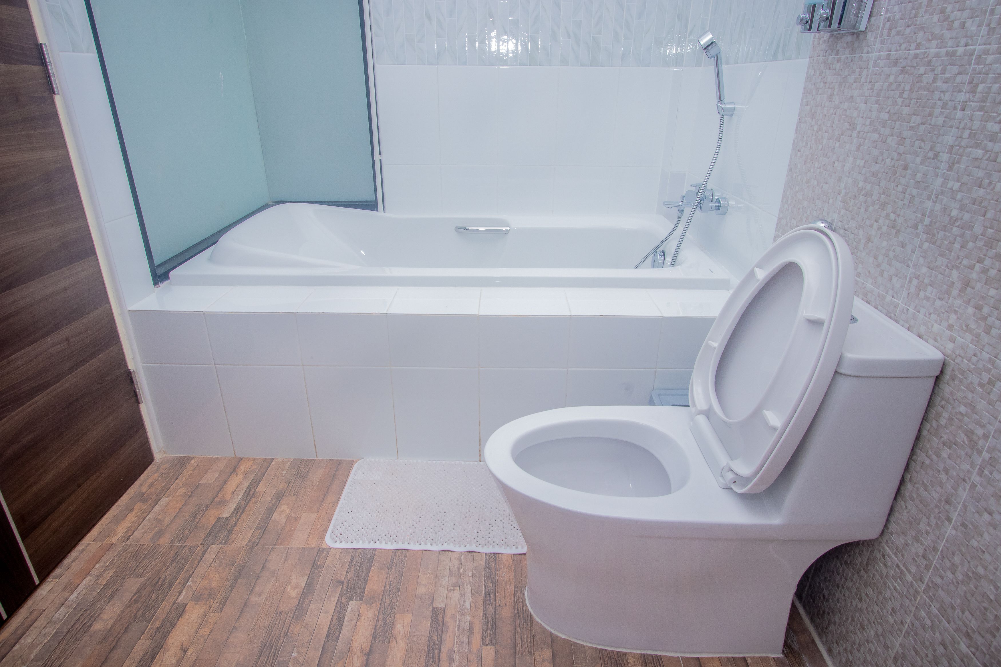 Un baño moderno con bañera, inodoro y zona de ducha.