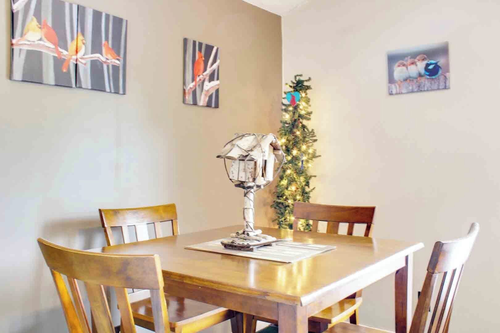 Un coin repas avec une table et des chaises en bois, une lampe décorative et des œuvres d’art murales.
