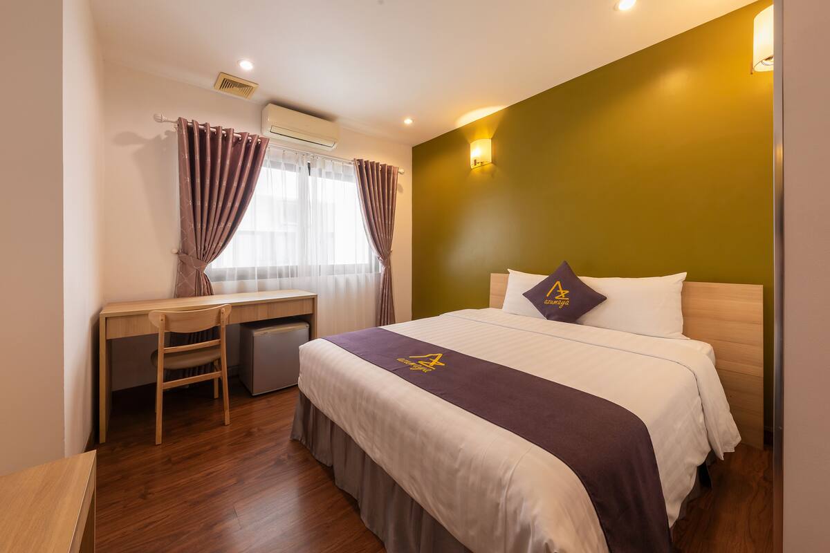 Une chambre d’hôtel avec un lit, un bureau et une chaise.