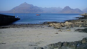 A rocky beach with a clear view of mountains in the background. - SPACIOUS FAMILY FRIENDLY - AMAZING SEA VIEWS - SLEEPS 4-6 (Isle of Skye)