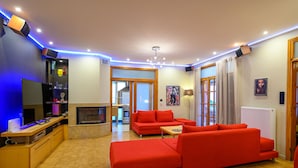 Un salon moderne avec un canapé rouge, un téléviseur et une cheminée.