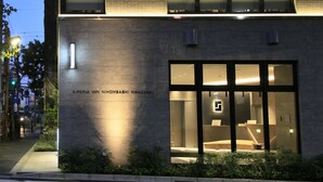 L’extérieur de l’hôtel S-peria Inn Nihombashi Hakozaki se distingue par sa façade moderne, avec de grandes fenêtres en verre et une entrée bien éclairée.