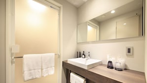 Une salle de bain avec un lavabo blanc, un miroir et un porte-serviettes.