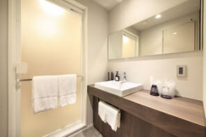Een badkamer met een wit wastafel, een spiegel en een handdoekhouder.