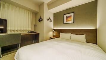 A hotel room with a bed, a desk, a television, and a wall-mounted picture.