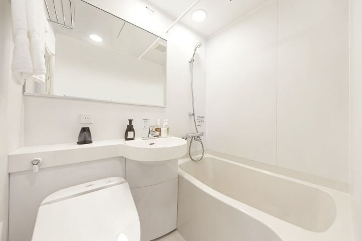 A modern bathroom with a toilet, sink, and bathtub.