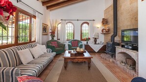 Una sala de estar acogedora con sofá, sillones, una mesa de centro, chimenea y televisor.