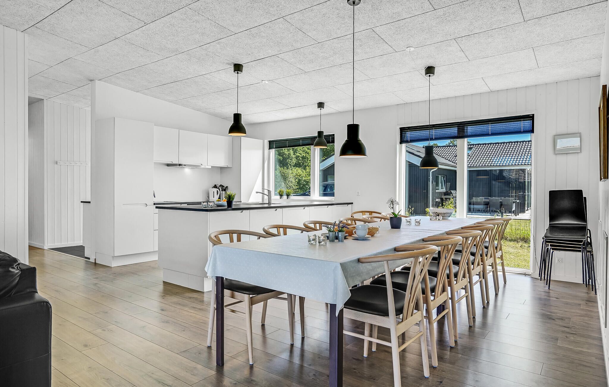 A modern kitchen with white cabinets, a central island, and pendant lighting.